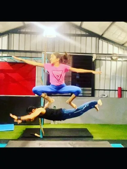 Partner acrobatics are a core part of my training. Here, I'm the base for a student performing a complex acro yoga pose, demonstrating the trust and strength we build together.