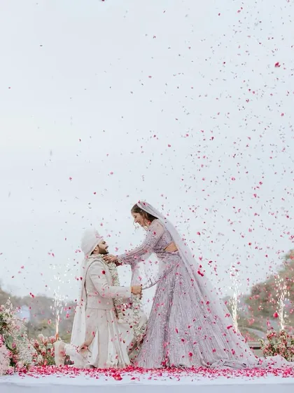 The moment the bride places the varmala on the groom, a playful and cherished tradition. The grand floral arrangements and petal shower make the moment even more special.