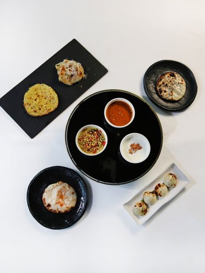 Another presentation of our bread bar, showcasing different types of kulchas and parathas on various plates. It’s a central part of the Indian Accent experience.