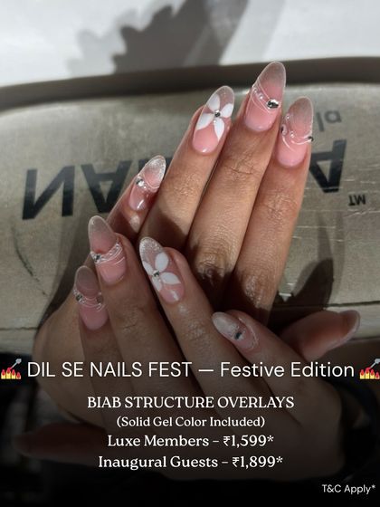 A beautiful example of BIAB structure overlays with delicate nail art. This design features a sheer base with white floral patterns and silver accents, creating a strong yet elegant look.
