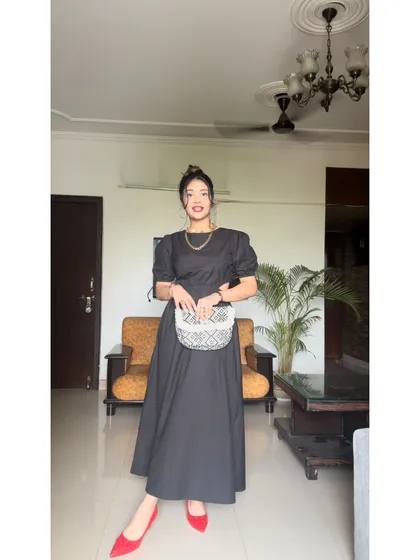 A full-length view of this elegant black midi dress. It’s a versatile piece that can be dressed up or down for any occasion.