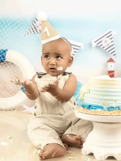 The aftermath of a successful cake smash. This little one is covered in cake and happiness, a perfect memory of his first birthday.