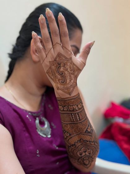 The bride showcasing her stunning geometric mehendi, which extends gracefully up her arm.