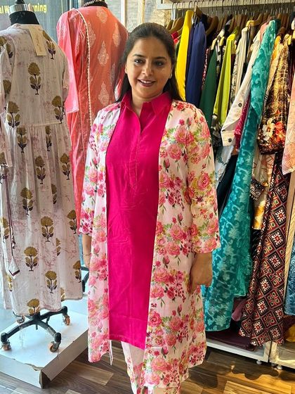 A client looking lovely in a three-piece ensemble. The pink kurta and pants are layered with a floral print jacket for a fresh and vibrant look.