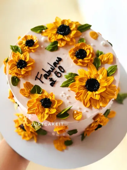 A beautiful cake decorated with hand-piped buttercream sunflowers. This design is cheerful and perfect for celebrating a "Fabulous at 50" milestone.