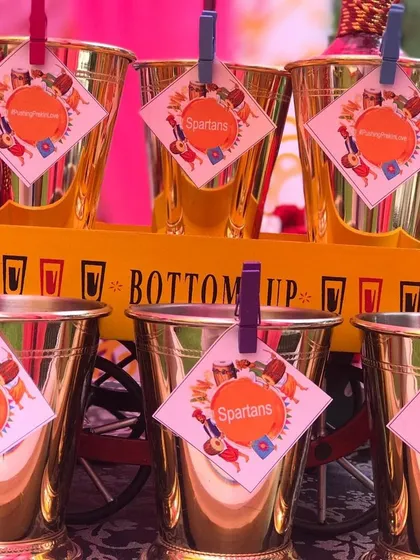 Getting the details right with custom glass tags and 'Bottoms Up' branding. These golden goblets are ready for a fun-filled Punjabi party, ensuring every element matches the vibrant theme.