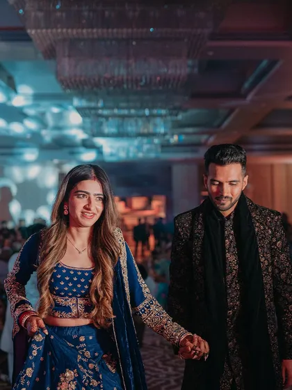 A candid shot of the couple making their entrance, hand in hand. The bride's joyful expression says it all.