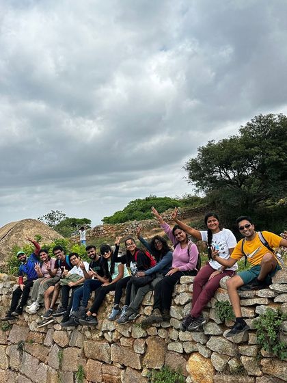 A group of friends relaxing on a historic fort wall, enjoying the cloudy weather and good company.