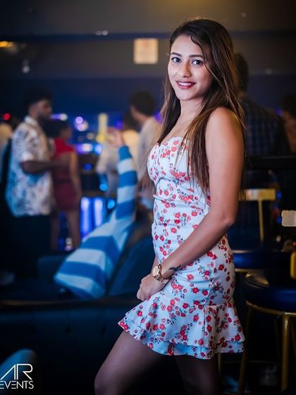 A guest posing at the entrance of Sugar Factory. The venue's vibrant decor and photo-op spots make it a favorite among the city's party-goers.