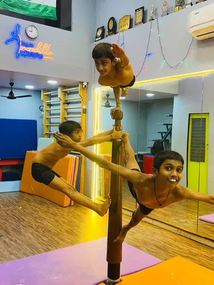 We believe in teamwork and pushing boundaries. Here, our advanced students demonstrate incredible strength, balance, and coordination, performing a complex group formation on the Mallakhamb pole. This level of acrobatic skill is built through consistent practice and mutual support.