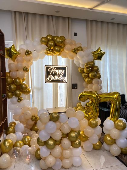 A different angle of the cream, white, and gold 37th birthday decoration.