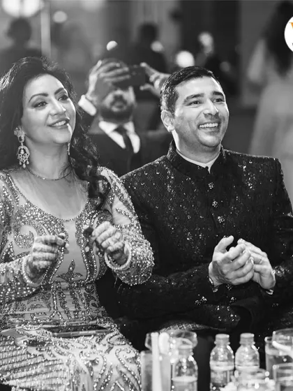 Capturing the joy of the family as they watch the Sangeet performances, a testament to a well-planned and engaging event.