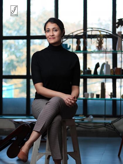 A seated portrait in a professional setting. The large window provides beautiful natural light, creating a soft yet defined look.