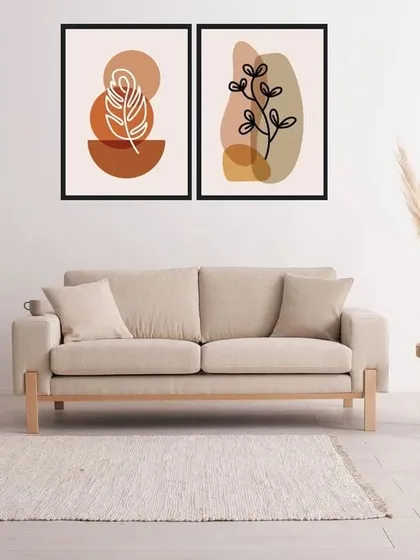 This set of two framed art prints showcases abstract botanical line drawings against earthy, colored shapes. The simple, clean aesthetic is perfect for a minimalist or Scandinavian-inspired interior.