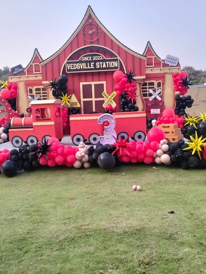 A wide shot of the impressive Vedsvillie Station setup. This image captures the full scale of the custom-built station, train, and extensive balloon decorations, showcasing our expertise in creating large, immersive themed environments.