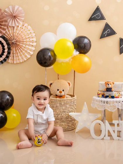 A classic first birthday setup with black, white, and yellow decor. This little boy is ready to celebrate turning one.