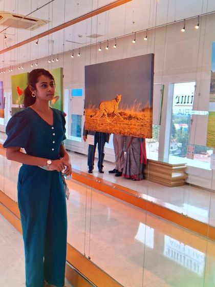 A visitor at the 'Nature's Splendour' exhibition, surrounded by stunning wildlife photography.