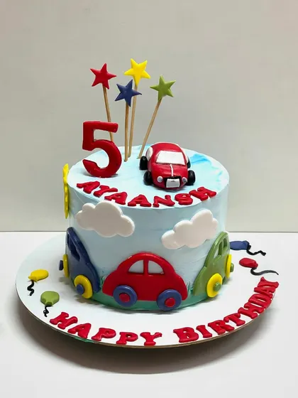 A car theme cake for a 5th birthday. This chocolate truffle cake is decorated with colourful fondant cars and stars.