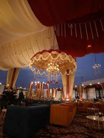 A beautiful shot of the lounge area at dusk, with ornate umbrellas and chandeliers creating a warm and inviting glow.