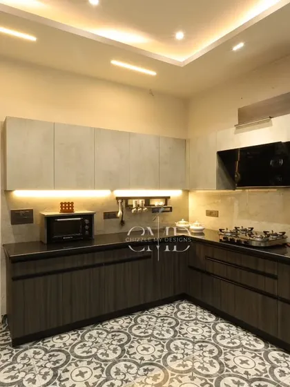 This monochrome-themed kitchen in Noida proves that functional spaces can be incredibly stylish. I used a blend of grey and dark wood laminates, patterned floor tiles, and strategic under-cabinet lighting to create a kitchen that is practical, visually engaging, and a joy to cook in.