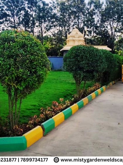 This image shows the clean edges and healthy growth of the lawn we installed, bordered by colorful kerbstones and manicured topiary shrubs.