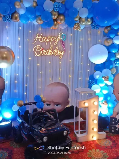 For a first birthday, a Boss Baby theme is always a hit. We created this complete setup with a blue and gold balloon arch, character cutouts, a light-up marquee number '1', and a 'Happy Birthday' neon sign.