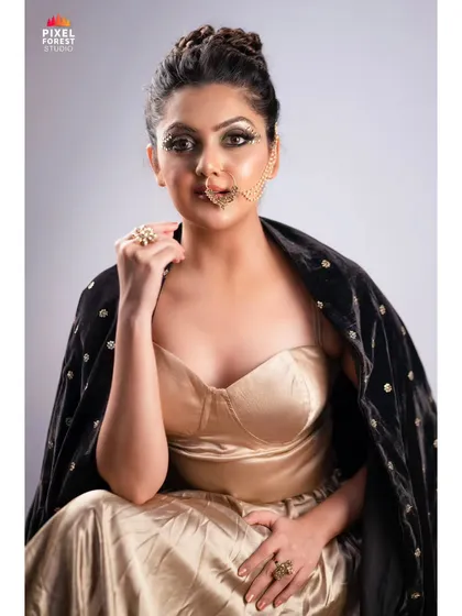 A golden, glamorous look with a unique chain nose accessory, showing how to incorporate unconventional elements into a makeup look.