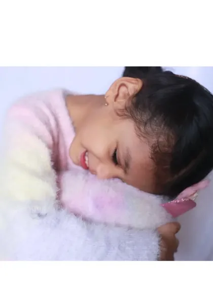 A burst of pure joy. In this shot, the little girl is hugging her toy with a huge, happy smile. These are the authentic, emotional moments I strive to capture in every session.