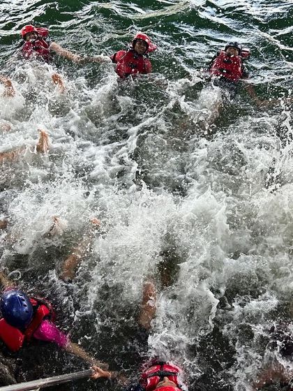 A group of participants creates a huge splash in the water, a moment of pure, uninhibited fun.