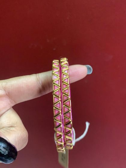 A collection of my pink silk thread bangles, showcasing a variety of designs from simple geometric patterns to elaborate floral kundan work.