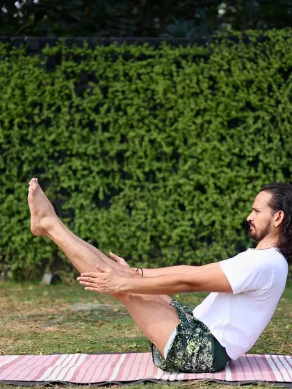 Holding Navasana (Boat Pose) requires immense core strength and stability. This fundamental posture from the primary series is excellent for strengthening the abdominal muscles and improving digestion. Here, I am practicing outdoors, connecting the energy of the earth with the fire of the practice.