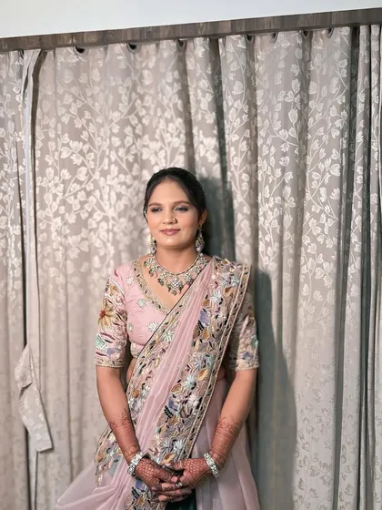 A mother of the bride, looking elegant and graceful in a pink saree for her daughter's wedding.