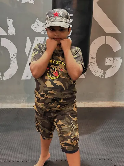 A young student in his army-style outfit, ready to train. We instill a sense of discipline and readiness in our youngest members.