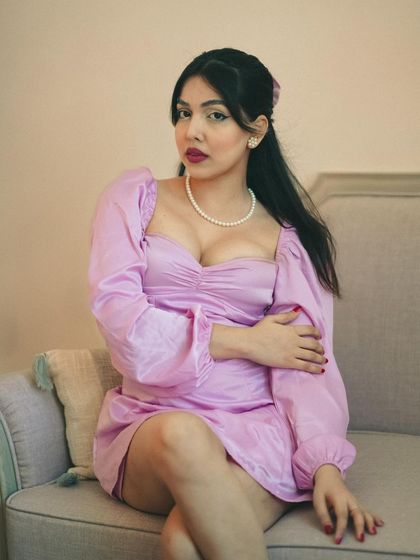 A classic portrait with a vintage feel. The pearl necklace, the dress style, and the soft lighting all come together to create a timeless, elegant look.