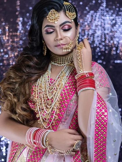 For brides who don't want a traditional updo, soft, side-swept waves are a beautiful alternative. This style adds a touch of modern romance and works wonderfully with almost any bridal lehenga.