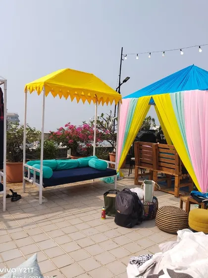 A view of the terrace setup in Bandra, showing a stylish swing seat and a decorated cabana. We can transform any open space, like a terrace, into a chic venue for your celebrations.