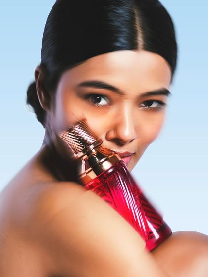 Fragrance photography is about evoking a feeling. I used a soft focus and a dreamy blue background to create a sense of fantasy and escape. The model's interaction with the bottle is intimate, suggesting the personal nature of a scent.