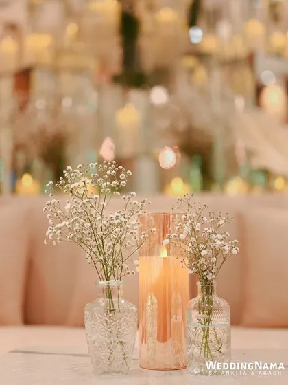 A simple yet elegant table centerpiece with baby's breath and a candle in a tinted glass holder.