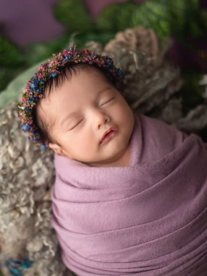 A close up of this sleeping beauty, wearing a colorful floral crown and surrounded by greenery and daisies. The mix of colors and textures is just lovely.