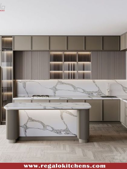 Modern textures and materials define this island kitchen. We used fluted paneling on the island and upper cabinets, paired with a striking marble backsplash. The rounded corners of the island soften the contemporary design.