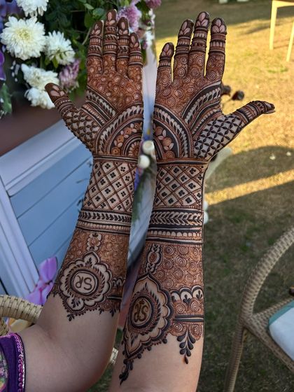 Monograms add a classic and personal touch. This design features the couple's initials 'SR' inside an ornate mandala, making the mehandi truly their own.