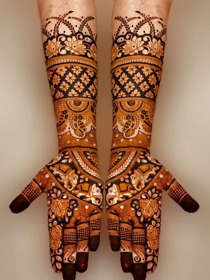 A stunning example of negative space design, where bold elephant and floral motifs are highlighted against a dark henna background.