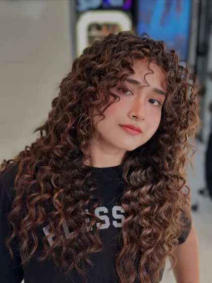 A full view of these stunning, rule-making curls. The color enhances the texture and gives the hair a vibrant, healthy look.