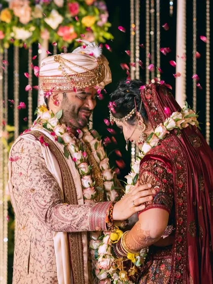 A joyful moment during the wedding ceremony, with flower petals showering the happy couple.