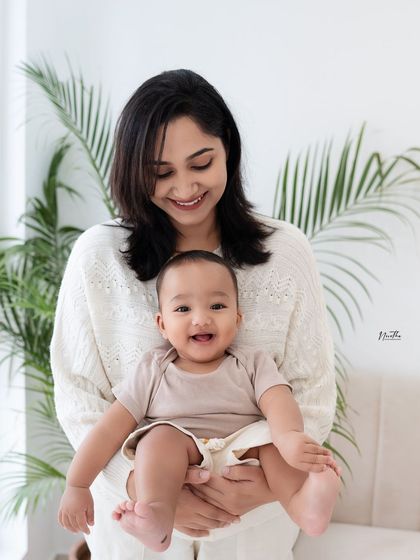 A mother holding her smiling baby.
