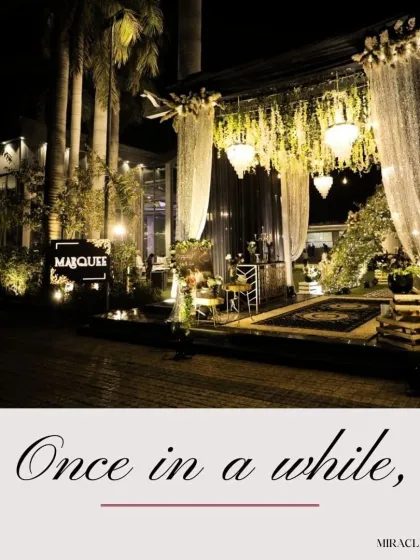 An elegant outdoor Sangeet setup at the "Marquee" venue, showcasing a beautiful entrance with chandeliers and drapes.