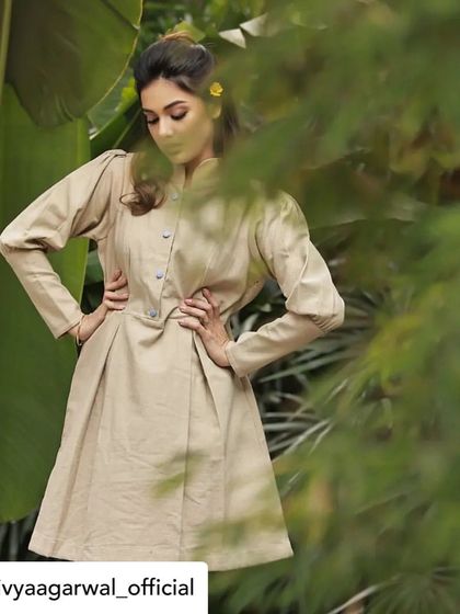 The elegant silhouette of our beige tunic dress, as seen on Divya Agarwal. The pleats and tailored waist provide a flattering A-line shape.