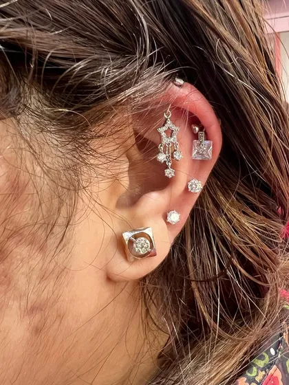 A sophisticated and modern ear stack with a hanging star chandelier and square solitaire studs.