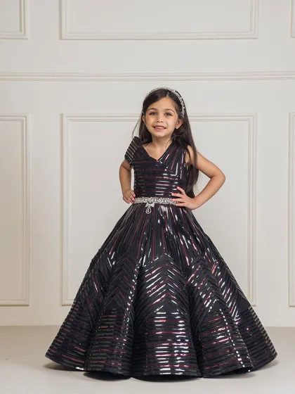 For a modern and glamorous look, we created this black taping gown. The full, structured skirt and geometric sequin pattern make it a showstopper, perfect for birthdays, pageants, or any formal event where she wants to shine.