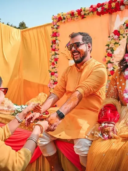 We focus on capturing the interactions between you and your loved ones. This shot shows a family member performing a ritual during the Haldi, with the couple enjoying the moment.